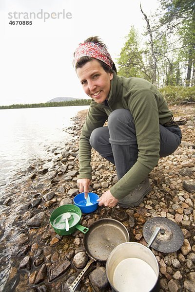 Frau beim Abwaschen am Strand