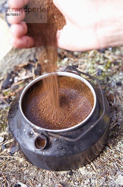 Kaffee von Hand in die Kanne gießen