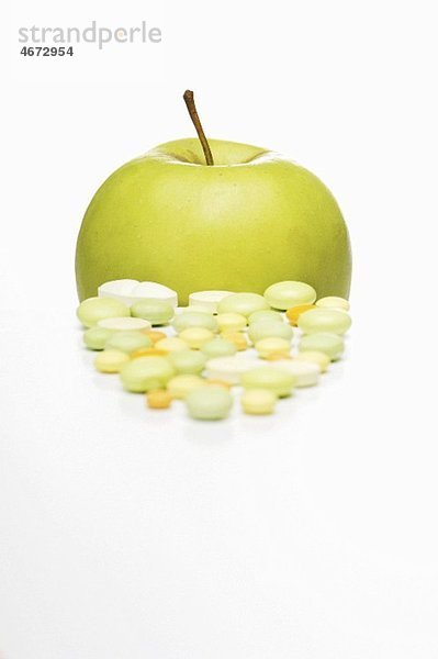 Vitamintabletten und Golden Delicious Apfel