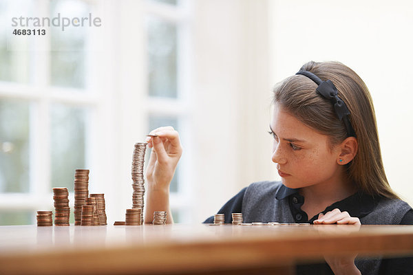 Mädchen Zählen von Geld am Tisch