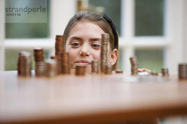 Mädchen schaut auf einen Haufen Geld.