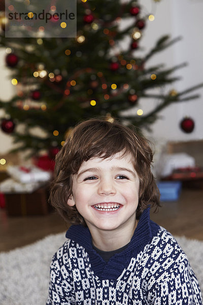 Junge vor dem Weihnachtsbaum