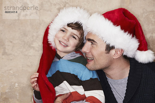 Vater und Sohn mit Weihnachtsmützen