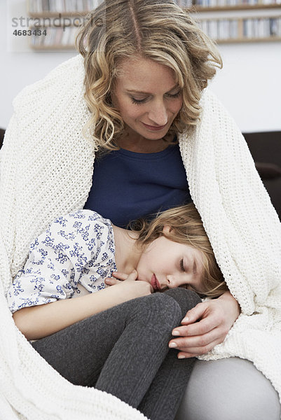 Mädchen schläft im Schoß der Mutter