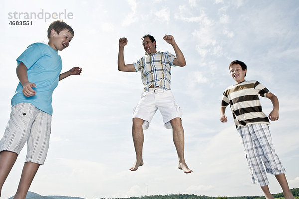 Vater und zwei Söhne springen