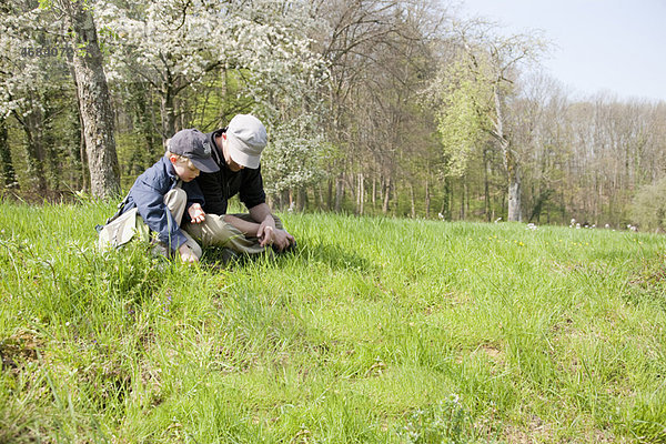 Vater und Sohn sitzen auf einem Feld.