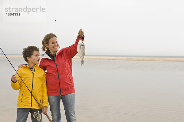 Mutter und Sohn schauen stolz auf Fische