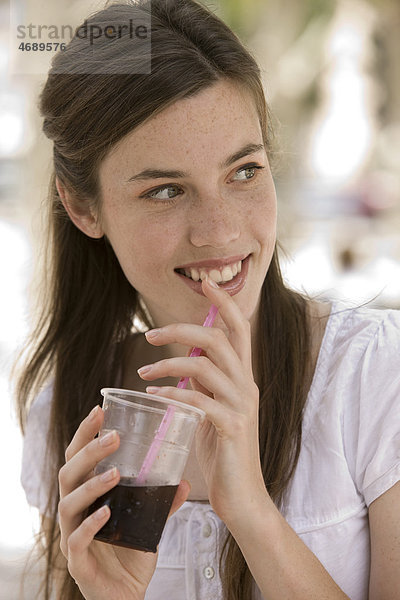 Junge Frau trinkt eine Cola