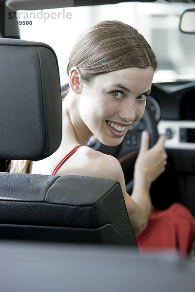 Lächelnde junge Frau in einem Auto