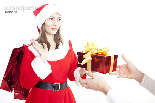 Frau im Weihnachtskostüm gibt ein Geschenk