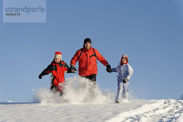 Kinder mit Vater im Schnee