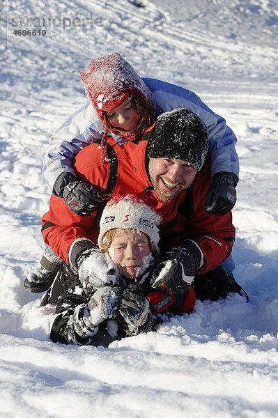 Kinder spielen mit Vater im Schnee  Schneespiele  einseifen