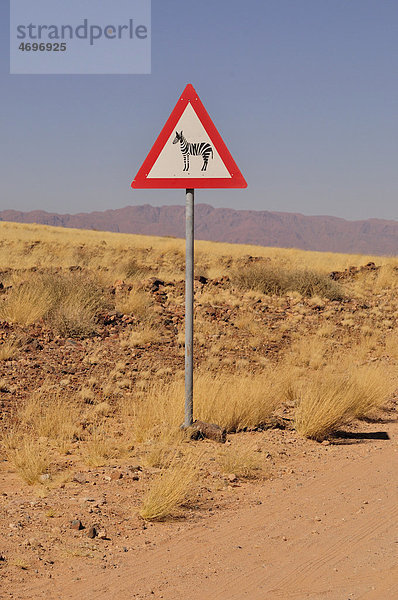 Warnschild vor Zebras am Eingang zum Namib Rand Nature Reserve  Namib-Wüste  Namibia  Afrika