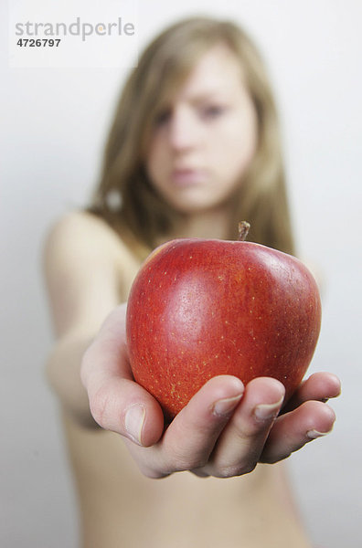 Junge Frau  nackt mit rotem Apfel in der Hand  Adam und Eva Motiv