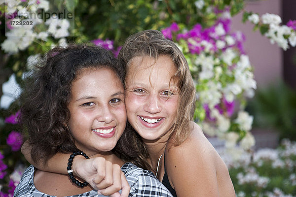 Porträt von zwei dreizehnjährigen Mädchen  hinten Blumen