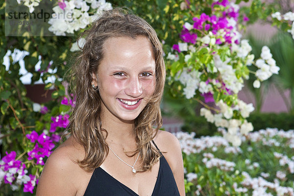 Porträt eines dreizehnjährigen Mädchens  hinten Blumen