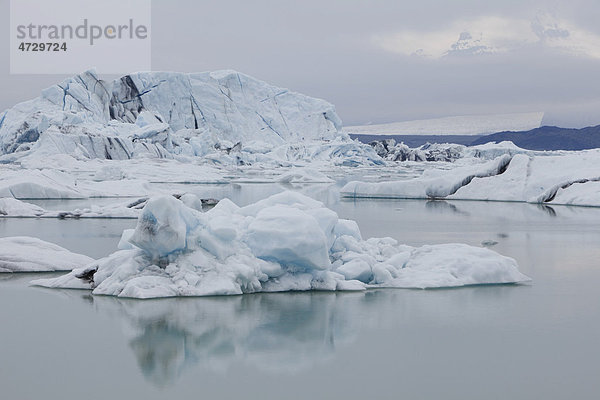 Eisberge spiegeln sich im ruhigen Gletschersee Jökulsarlon  Island  Europa