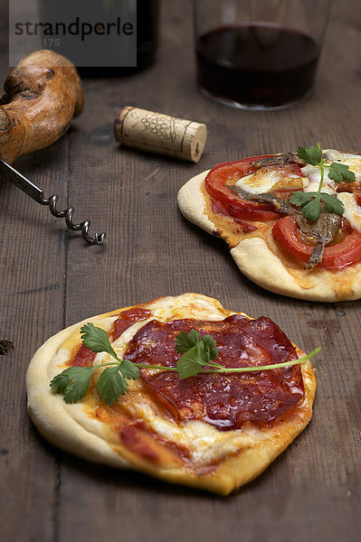 Pizzette mit Büffelmozzarella  Chorizo  Koriander  vorne  und Tomaten  Sardellen  hinten