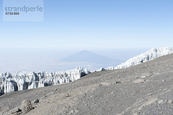 Wand aus Eis  Kersten Gletscher am Kraterrand des Kibo  Gipfel Uhuru Peak  erloschener Vulkan  hinten der Berg Mount Meru  Kilimandscharo Nationalpark  Marangu Route  Tansania  Ostafrika  Afrika