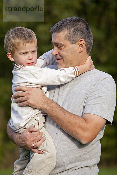 Vater trägt kleinen Sohn auf dem Arm