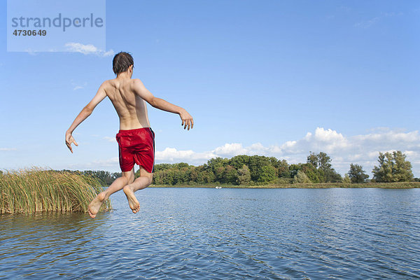 Junge springt von einem Steg in einen See  Teterow  Mecklenburg-Vorpommern  Deutschland  Europa