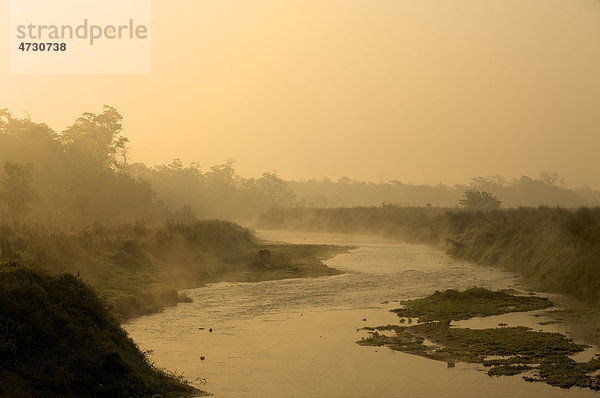 Morgenstimmung mit aufgehender Sonne und Nebel an kleinem Fluss  Chitwan Nationalpark  Nepal  Asien