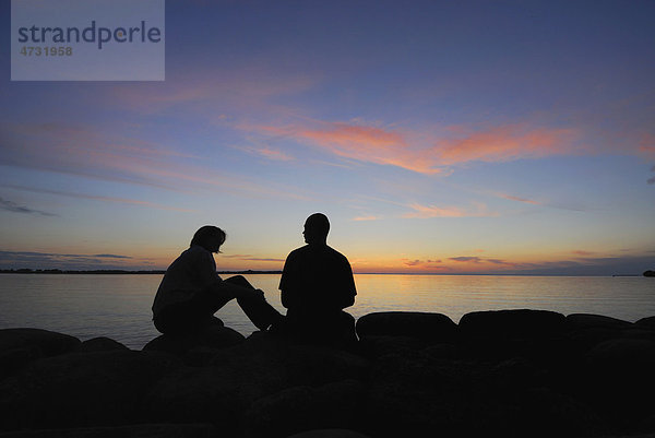 Silhouette eines Paares an einem See bei Sonnenuntergang  Schweden  Europa