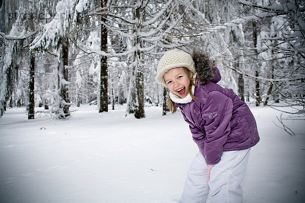 Mädchen spielt im Winterwald
