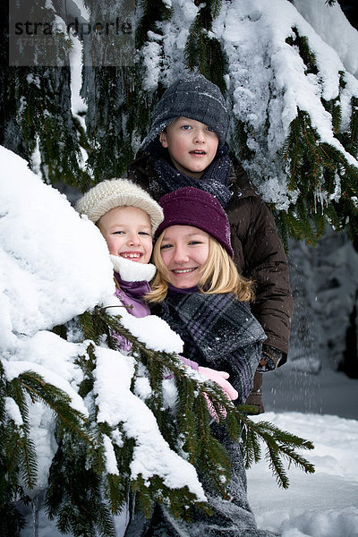 Kinder spielen im Winterwald