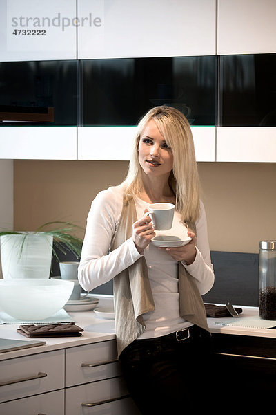 Junge Frau mit Kaffeetasse in der Küche