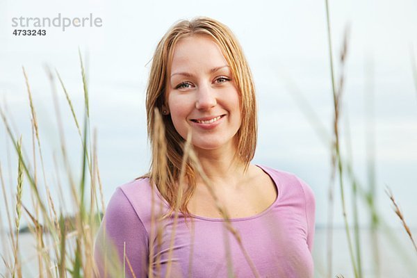 Porträt von lächelnde junge Frau hinter Gras