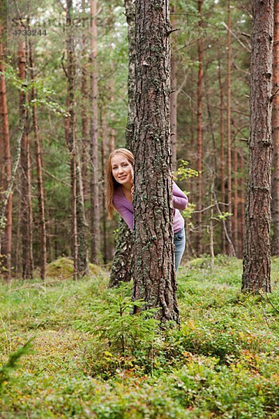 hinter junge Frau junge Frauen verstecken Baum Wald