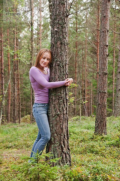 junge Frau junge Frauen verstecken umarmen Baum Wald