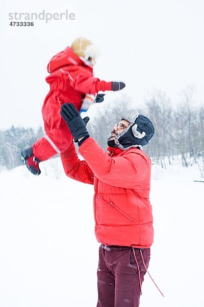 Außenaufnahme Winter Menschlicher Vater Kleidung Tochter freie Natur spielen
