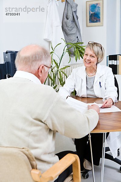 Arzt und Patienten sprechen in Klinik