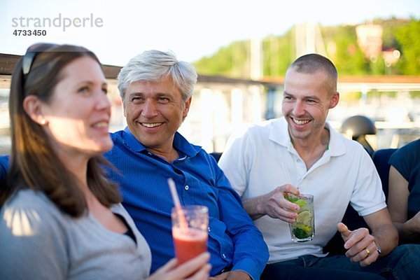 Entspannende drei Personen in Freiluftrestaurant