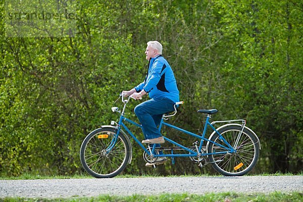 älterer Mann auf Tandem-Fahrrad