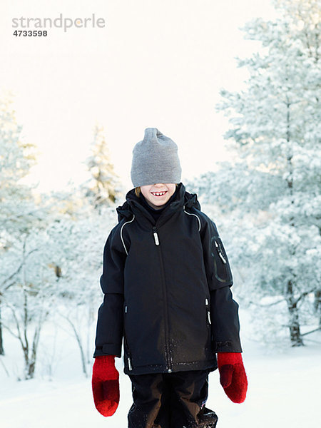 Boy tragen wooly Hut in Winterlandschaft