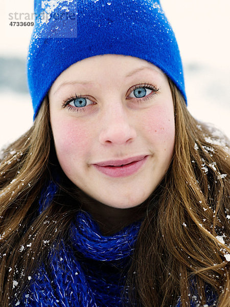 Portrait einer jungen Frau tragen blauen Hut und blau wooly Schal