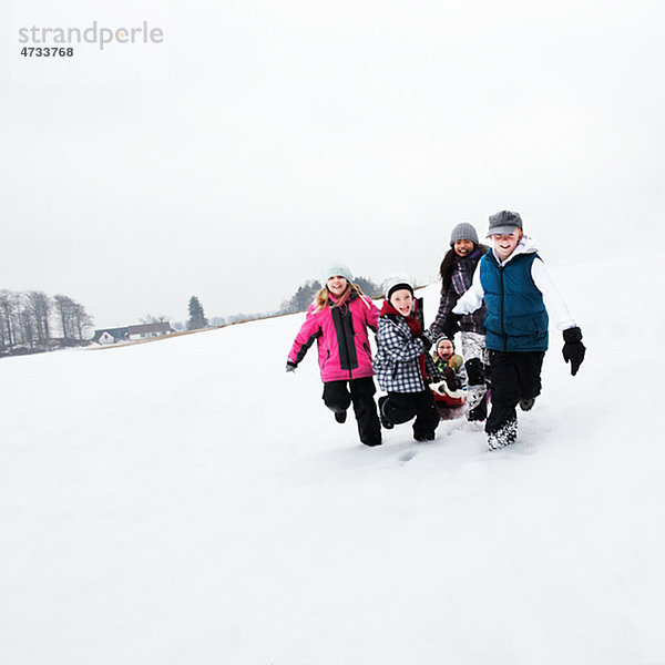 Kinder Rodeln auf Schnee Hang