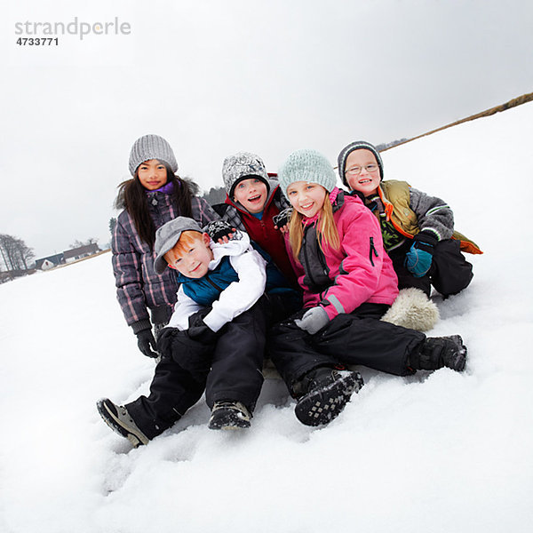 Portrait von Kindern sitzen im Schnee