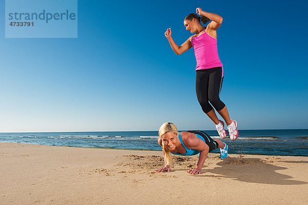 Zwei Frauen  sich fit halten am Strand