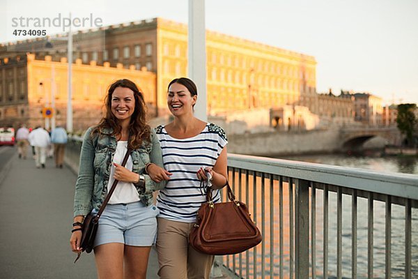 Zwei Frauen zu Fuß durch Brücke  lachen