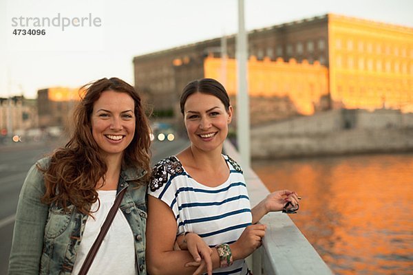 Zwei Frauen stehen auf Brücke  lächelnd