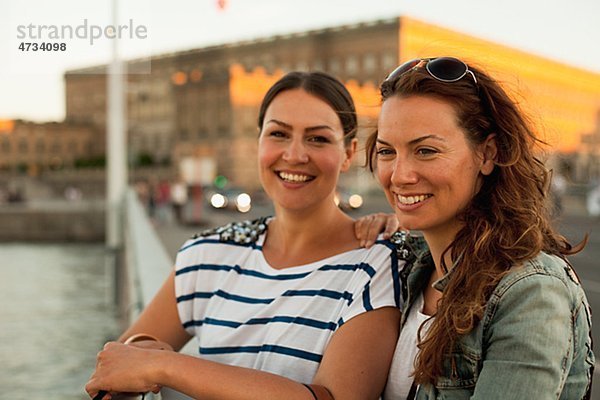 Zwei Frauen stehen auf Brücke  lächelnd