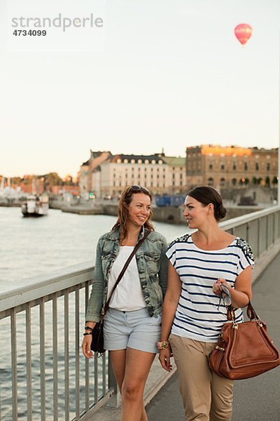 Zwei Frauen zu Fuß durch Brücke  lachen