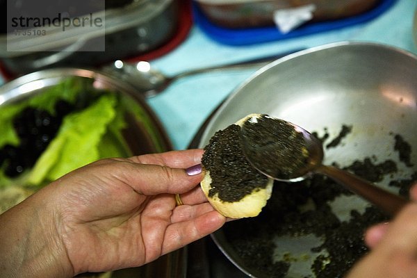 Küche-Mitarbeiter machen Knödel mit Spinat