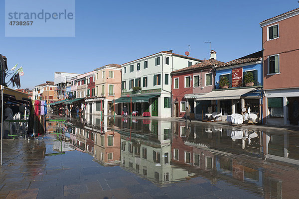 Das winterliche Hochwasser  aqua alta  überspült die Haupteinkaufsstraße  die Häuser spiegeln sich im Wasser  Insel Burano  Venedig  Italien  Südeuropa