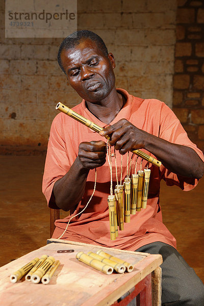 Mann bei der Herstellung eines Windspiels aus Bambus  Bafut  Kamerun  Afrika