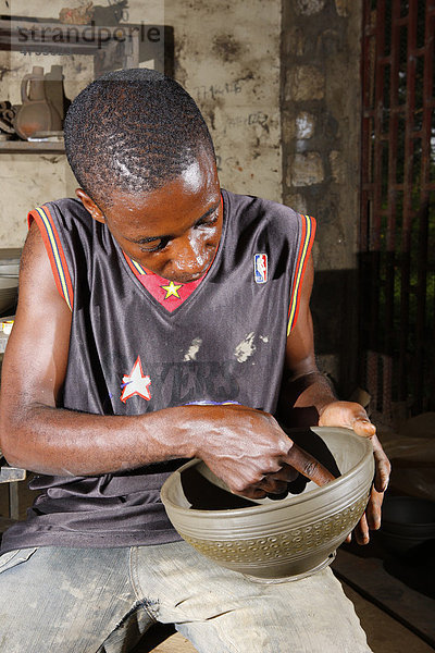 Mann mit Tonschüssel  Herstellung von Töpfereiprodukten  Bamessing  Kamerun  Afrika